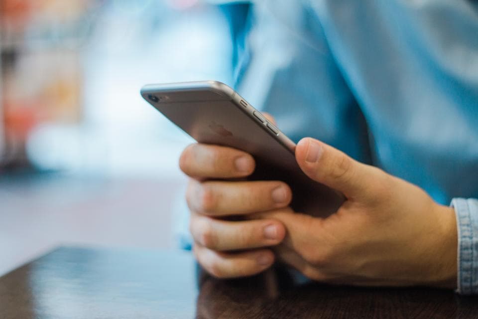 Человек читает отзывы на экране смартфона